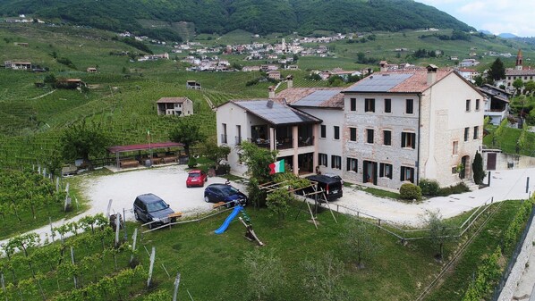 Un bâtiment à deux étages, doté d’un toit en pente, d’un drapeau et d’une aire de jeux.