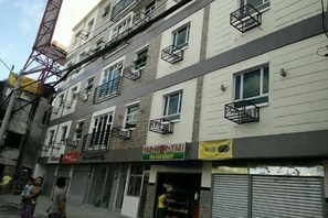 A multi-story building with various storefronts, including a bakery and a restaurant. - Aam Transient and Guest House (Pasay)