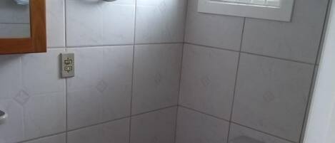 A small, clean bathroom with a toilet, sink, and a mirror.