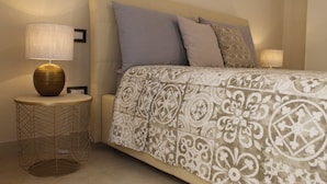 A neatly arranged bedroom with a bed, two bedside lamps, and a round side table with a lamp. - HomeAway B&B (Salerno)