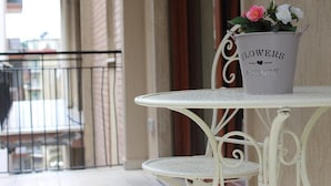 A white metal table with a flower pot labeled "FLOWERS GARDEN" on a balcony. - HomeAway B&B (Salerno)