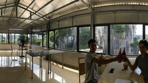 A spacious room with large windows offering views of a mountainous landscape. - Limestone Boutique Hotel (Ninh Binh)