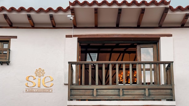 A building with a balcony, a sign reading 'SIE,' and a door with a decorative design. - Casa Sie (Villa de Leyva)