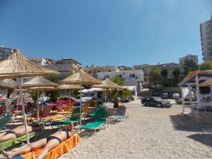 En privat strand, hvidt sand, liggestole