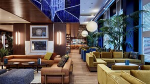 A modern lounge area with leather sofas, a bar, and a large mural on the wall. - Radisson Blu 1882 Hotel, Barcelona Sagrada Familia (Barcelona)