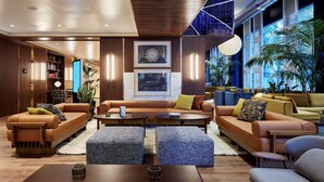 A modern lounge area with leather sofas, a central coffee table, and a bookshelf. - Radisson Blu 1882 Hotel, Barcelona Sagrada Familia (Barcelona)