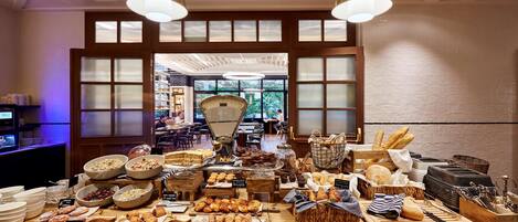 A bakery counter with various baked goods and pastries, a scale, and a coffee machine.