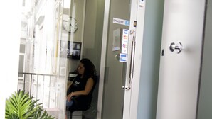 Entrada de hotel con un letrero que dice "NAPOLI Binario 1" y una mujer sentada adentro.
