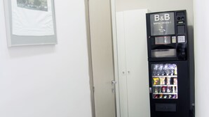Un pasillo con una máquina expendedora que dice 'B&B Napoli Central Binasio 1' y una puerta.