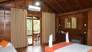A wooden cabin with two beds, a balcony, and an air conditioning unit.