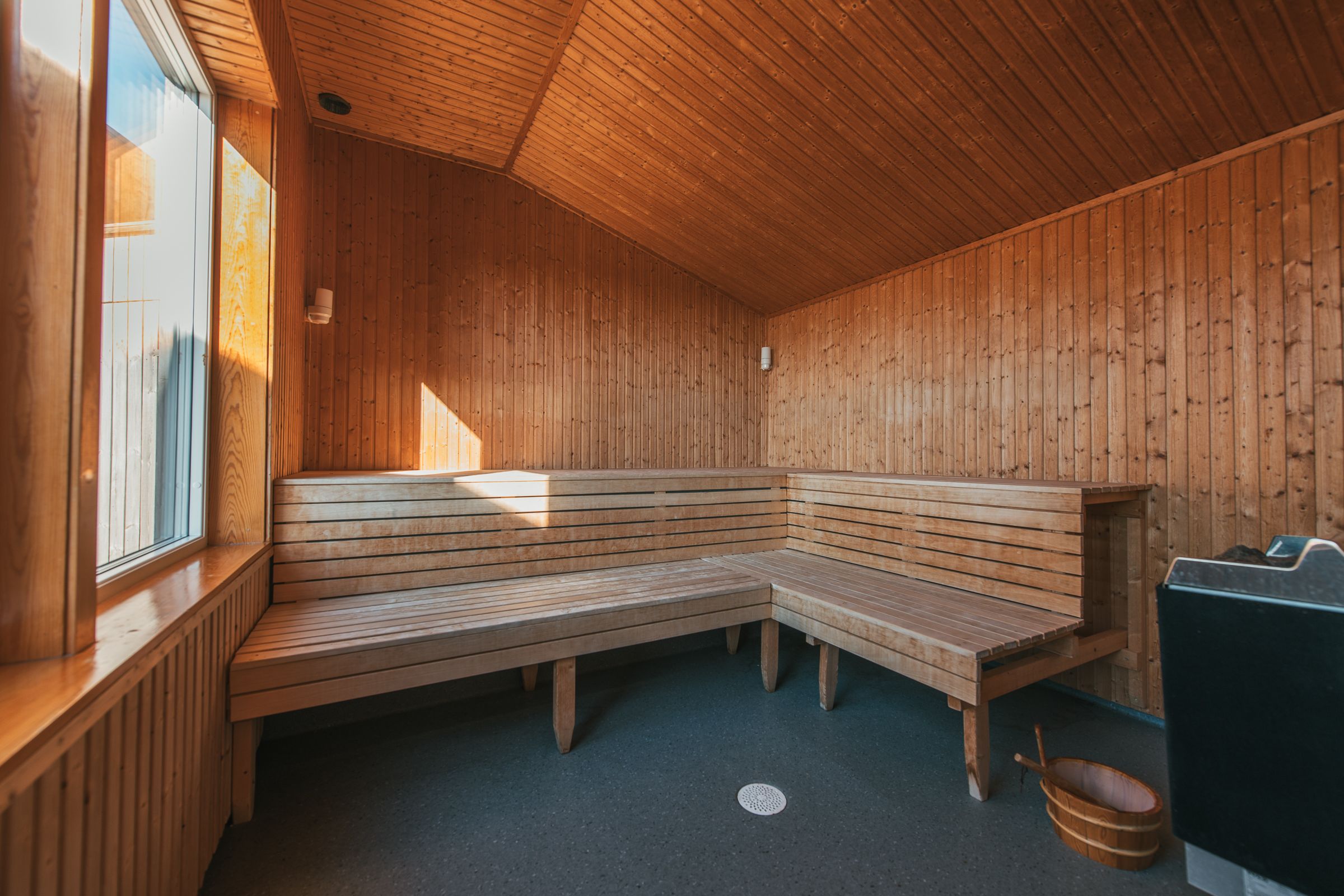 Un sauna avec des bancs en bois et un appareil de chauffage pour sauna.