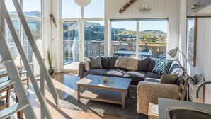 A spacious living room with a large window, a sofa, a coffee table, and a view of the outdoors. - Hav & Logi Skärhamn (Skaerhamn)