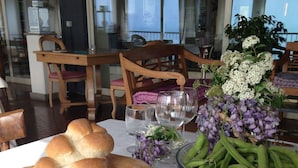 Una tavola apparecchiata con pane, piatti, un vaso di fiori e una ciotola di fagiolini.