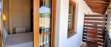 Un pasillo con un banco de madera, una ventana y una escalera de madera.