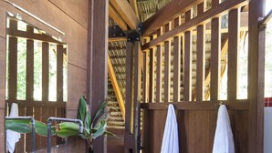 Une salle de bain rustique en bois, avec un lavabo en métal, un miroir et un porte-serviettes.
