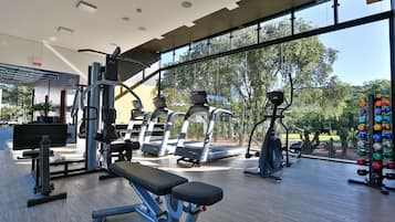 Un gimnasio moderno con cintas de correr, máquinas de pesas y un banco.