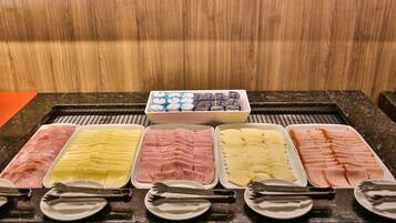 Un bufé con diferentes carnes y quesos.