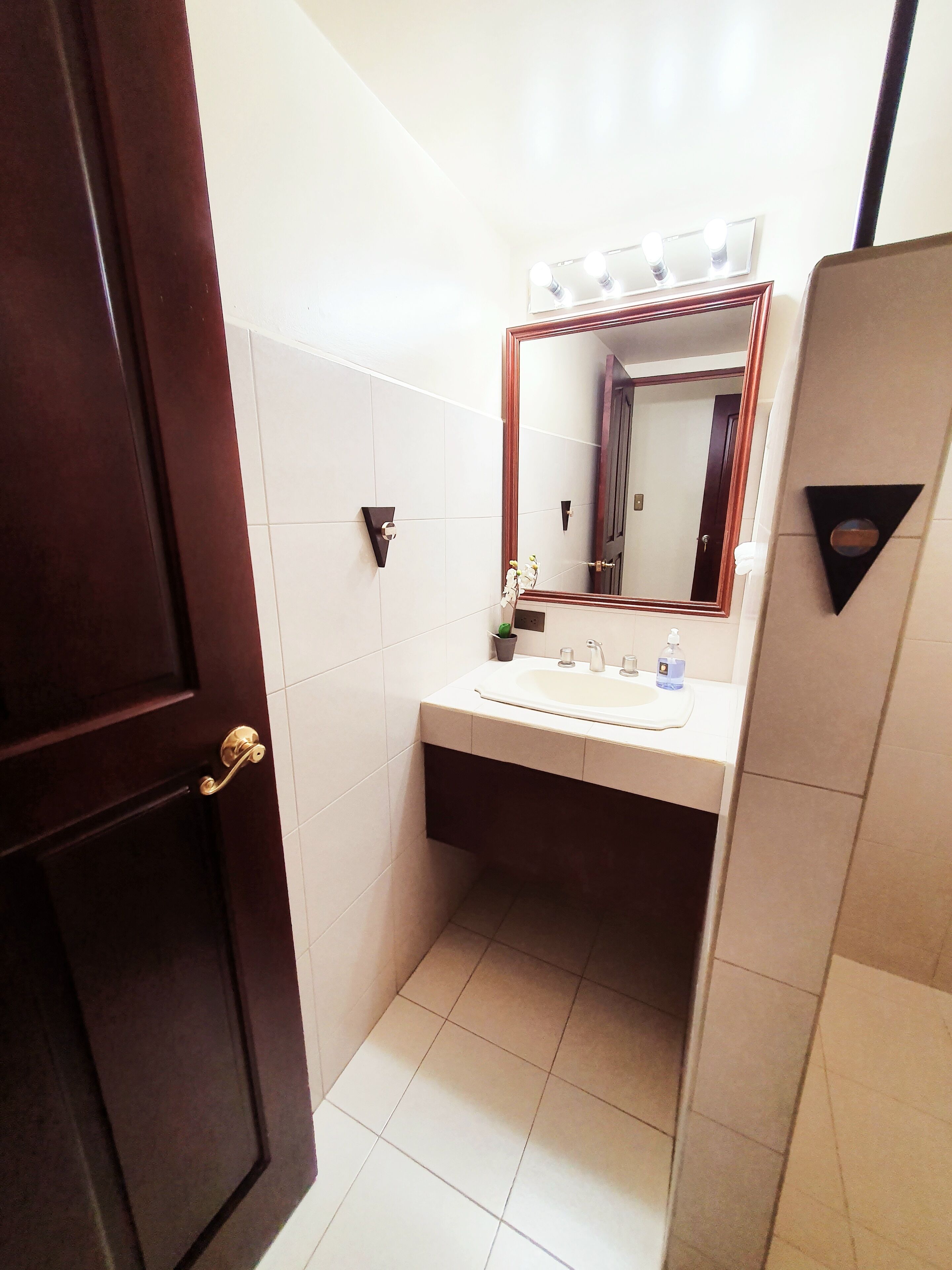 A bathroom with a sink, mirror, and vanity.