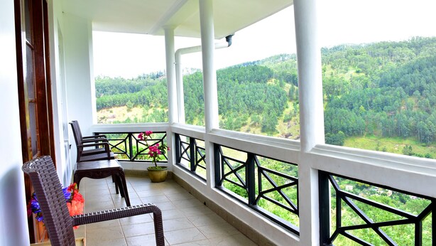 A balcony with a view of a forested hillside.
