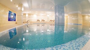 Una piscina techada, sillones reclinables de piscina