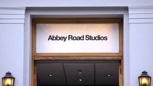 L’entrée des studios Abbey Road, avec une enseigne au-dessus de la porte et deux lampes fixées aux murs de part et d’autre.