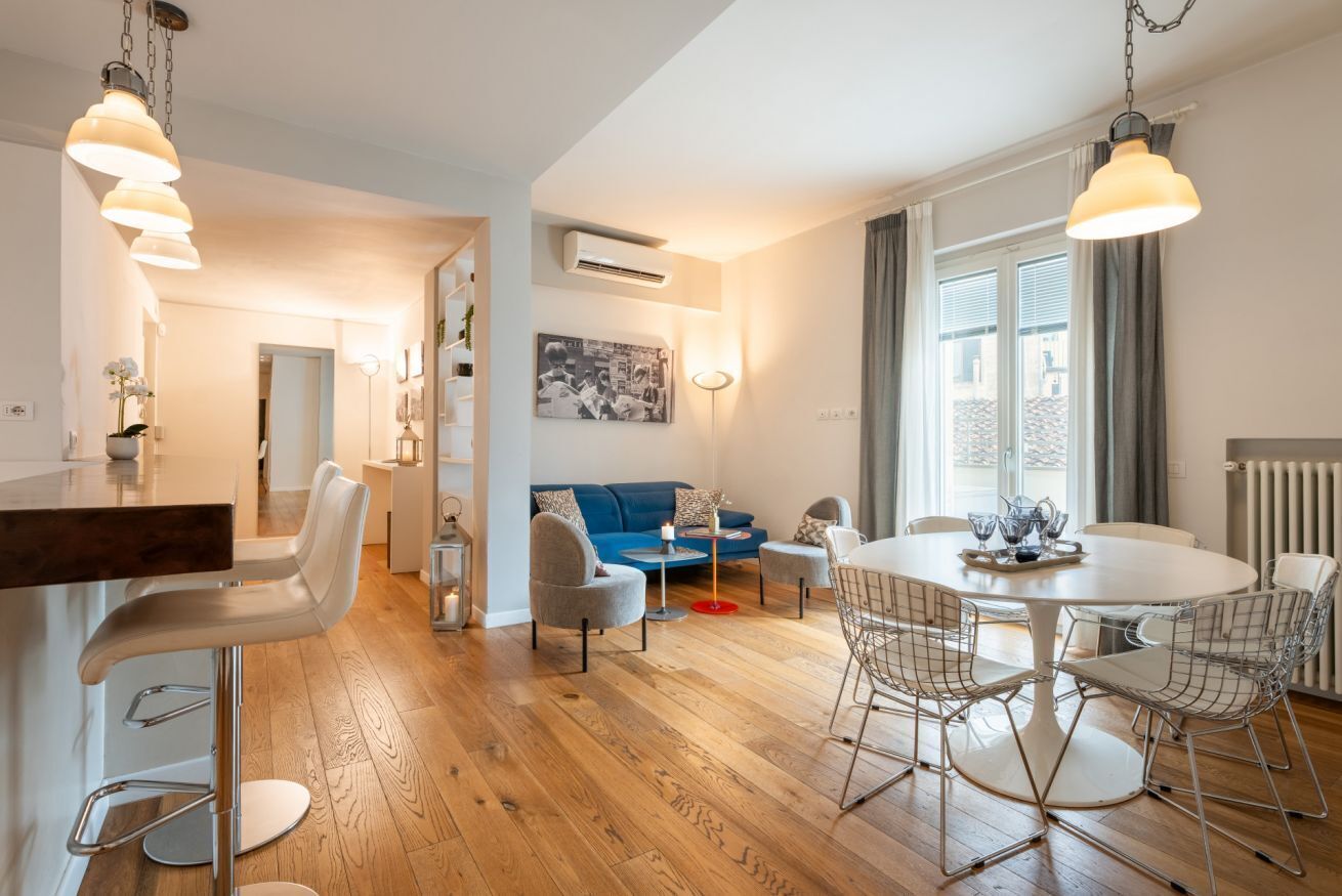 Un espacio de estar moderno con comedor, sofá y mostrador de cocina.
