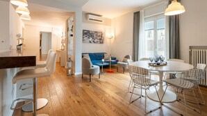 A modern living space with a dining area, a sofa, and a kitchen counter. - Apartments Florence - Ponte Vecchio Guelfo (Florence)