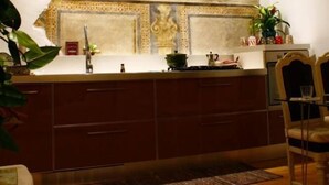 A kitchen with a marble countertop, wooden cabinets, and a decorative wall with a mosaic. - Bergamo: House with character (Bergamo)