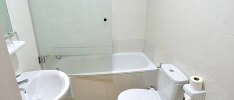 A bathroom with a shower, toilet, bidet, and sink.