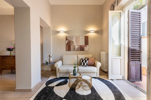 A living room with a sofa, a coffee table, and a decorative rug.