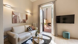 A modern living room with a sofa, coffee table, and artwork. - Apartments Florence - Alfani Terrace (Firenze)