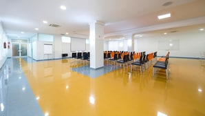 A spacious conference room with rows of chairs, a whiteboard, and a fire extinguisher. - HOTEL PLAYASOL MARE NOSTRUM (Ibiza Town)