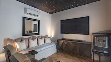 Ein modernes Wohnzimmer mit einer Couch, einer Kaffeemaschine und einem Flachbildfernseher.