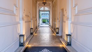 A grand hallway with a black doormat reading "Le Palais Gallien Bordeaux." - Le Palais Gallien Hôtel & Spa (Bordeaux)