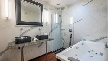 Un baño moderno con un espejo grande, dos lavamanos, una ducha a ras de suelo y una bañera independiente.