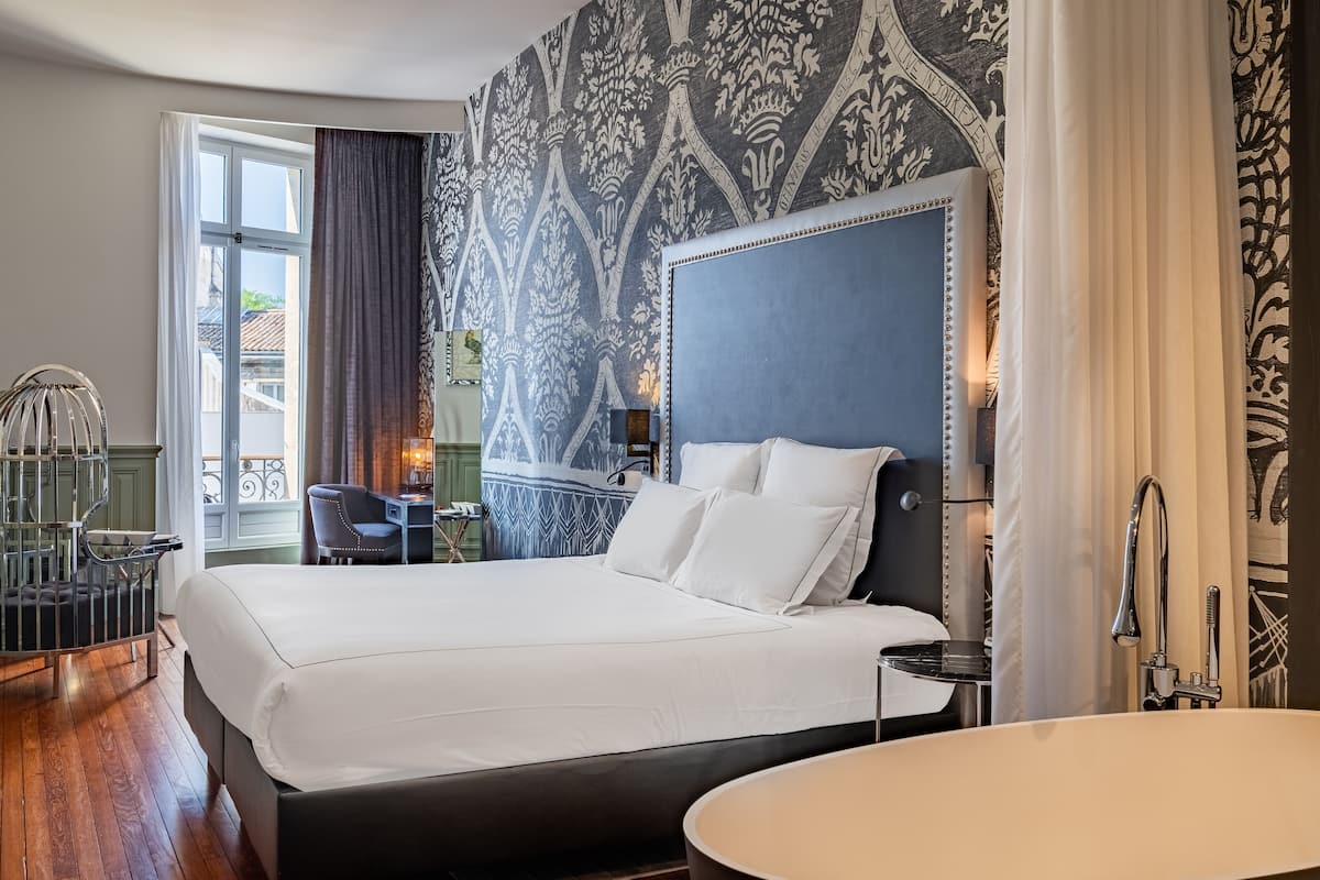 Una habitación de hotel con una cama grande, un escritorio y una silla.