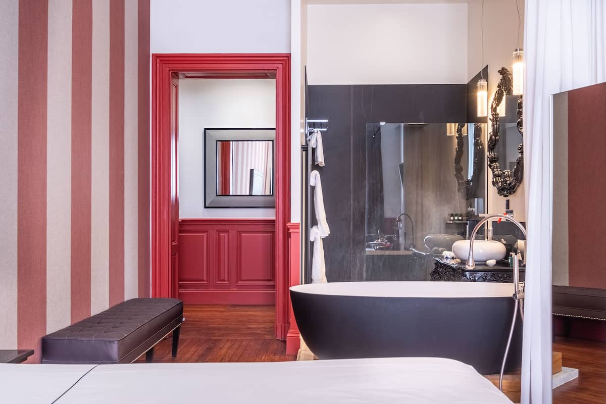 Un baño moderno con una bañera grande, un espejo y una zona de ducha.