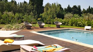 A poolside area with lounge chairs, a small table, and a sunbed. - Unique in Provence: the Mas Mirabelle in Eygalières (Eygalières)