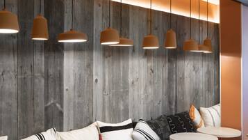A modern interior with wooden panel walls, round tables, and cushioned seating.