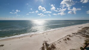 A beach with a wooden walkway leading to the water, sandy beach, and ocean. - The Oasis at Orange Beach  - Lazy River + Slide, Pools, Splash Pad, Cafe & Bar.. (Orange Beach)