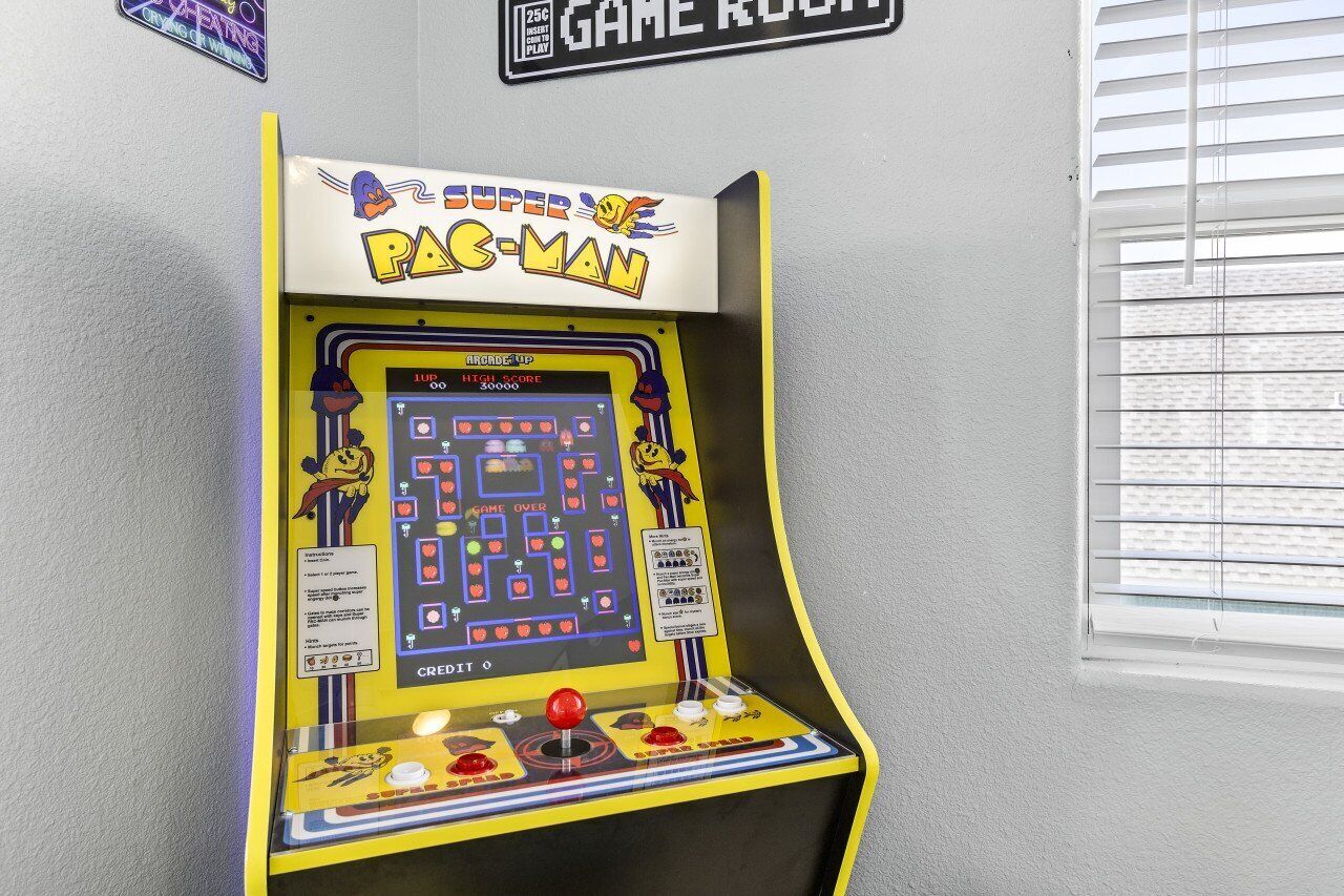 Un juego de arcade Pac-Man con una pantalla de puntuación alta e instrucciones.