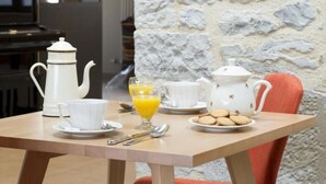 A breakfast table with a teapot, cups, a glass of orange juice, and cookies. - La Maison de Siloe (Villefranche-de-Rouergue)