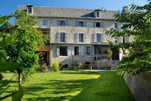 A stone building with multiple windows and a covered outdoor area. - La Maison de Siloe (Villefranche-de-Rouergue)