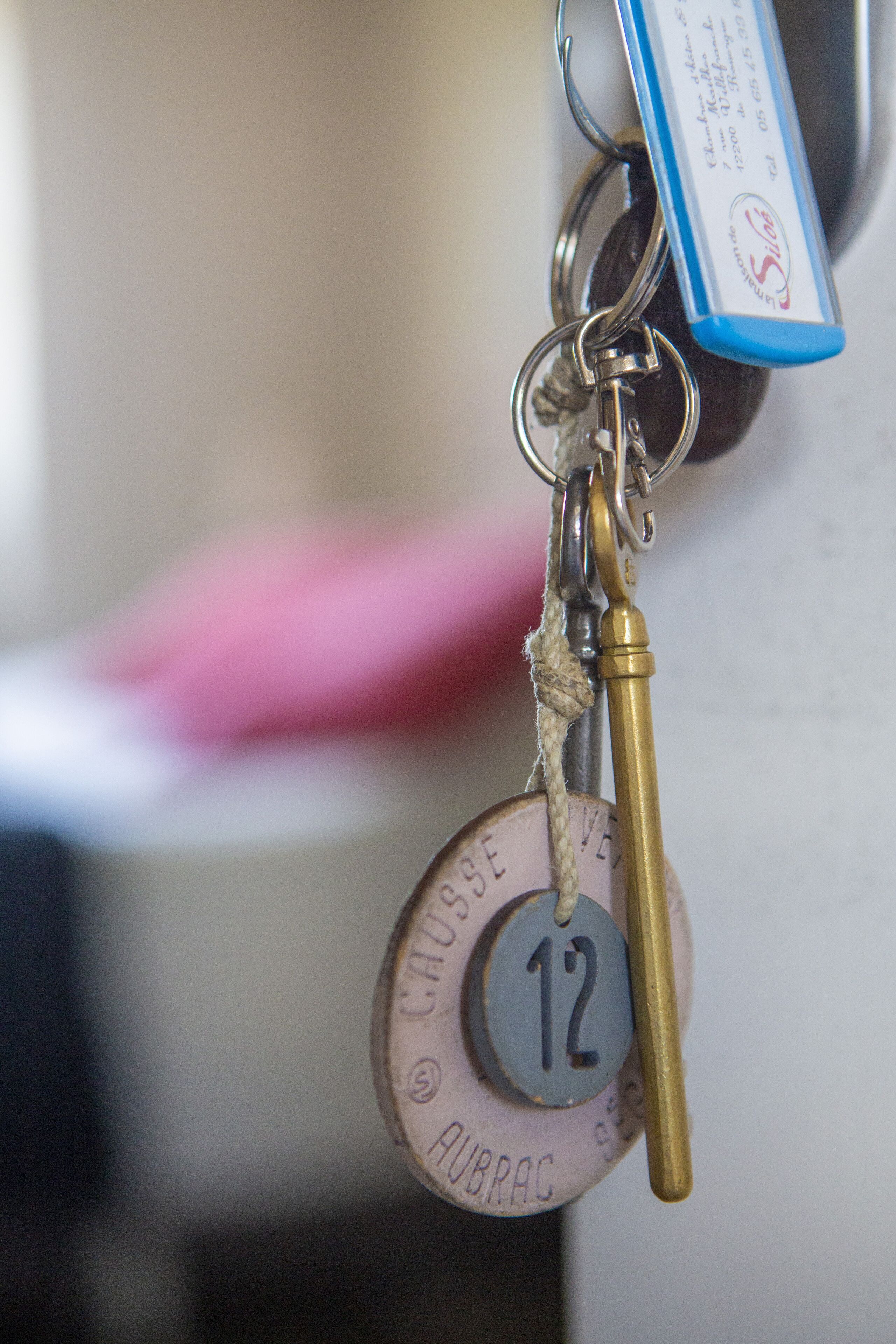 A keychain with a round metal tag labeled "12" and "AUBRAC."