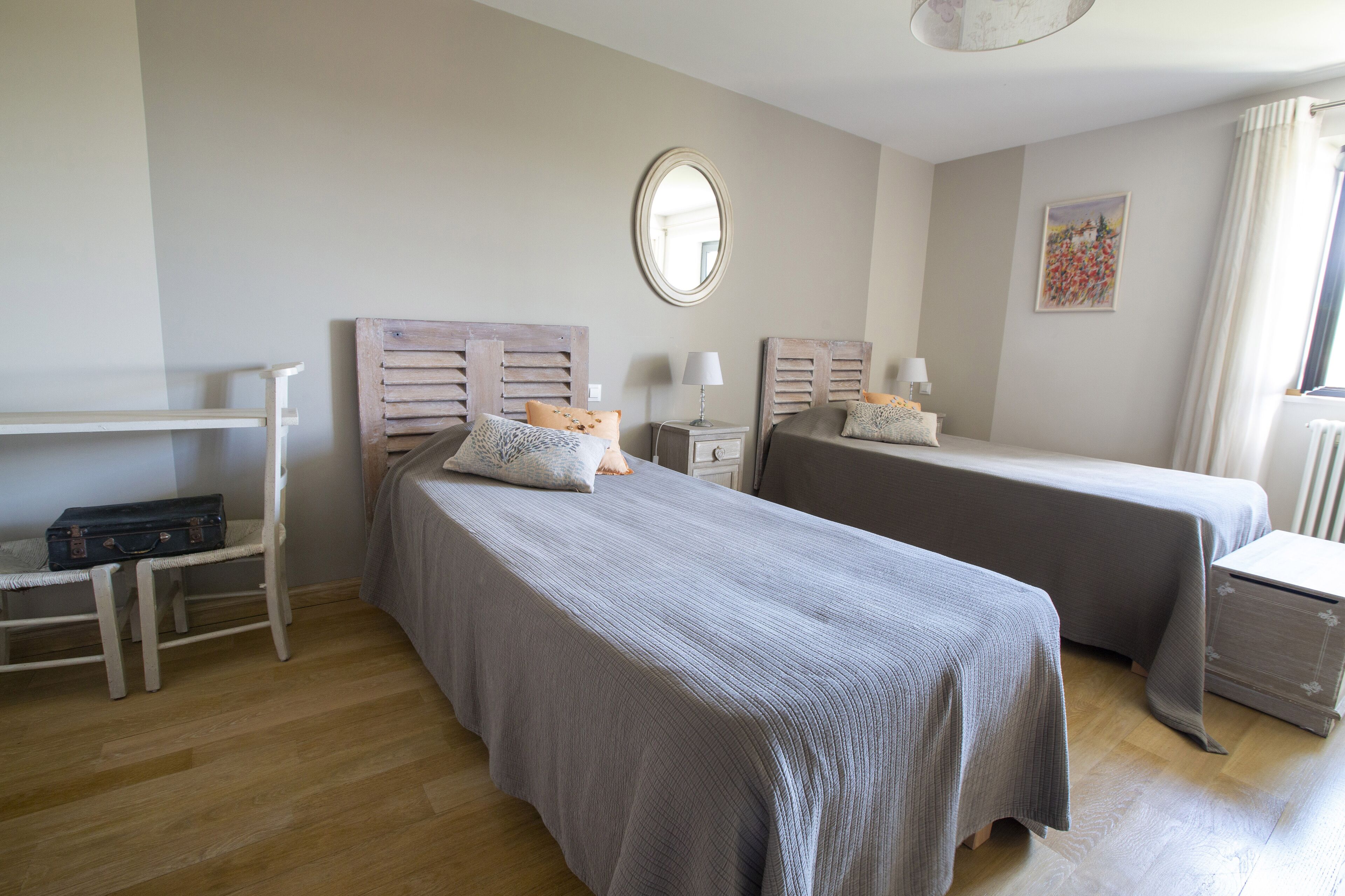 Un dormitorio con dos camas, un escritorio y una silla.