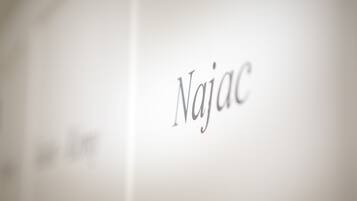 Een close-up van het woord 'Najac' op een witte achtergrond.