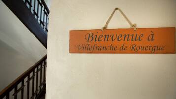 A welcome sign with the text "Bienvenue à Villefranche de Rouergue" hanging on a wall.