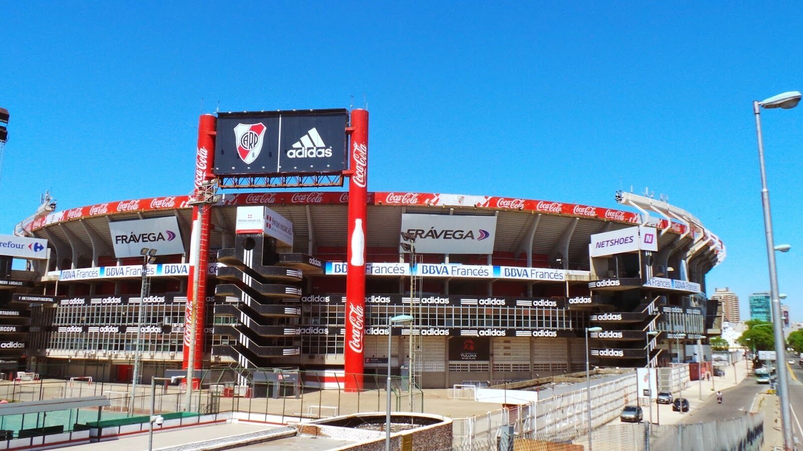 A stadium with multiple advertisements, including Coca-Cola, Adidas, and BBVA Francés.