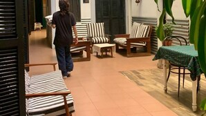 A spacious indoor courtyard with multiple seating areas, including striped sofas and chairs, a small table, and a potted plant. - Hotel La Barca (Buenos Aires)