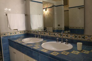 Une salle de bain avec deux lavabos, un miroir et un porte-serviettes.